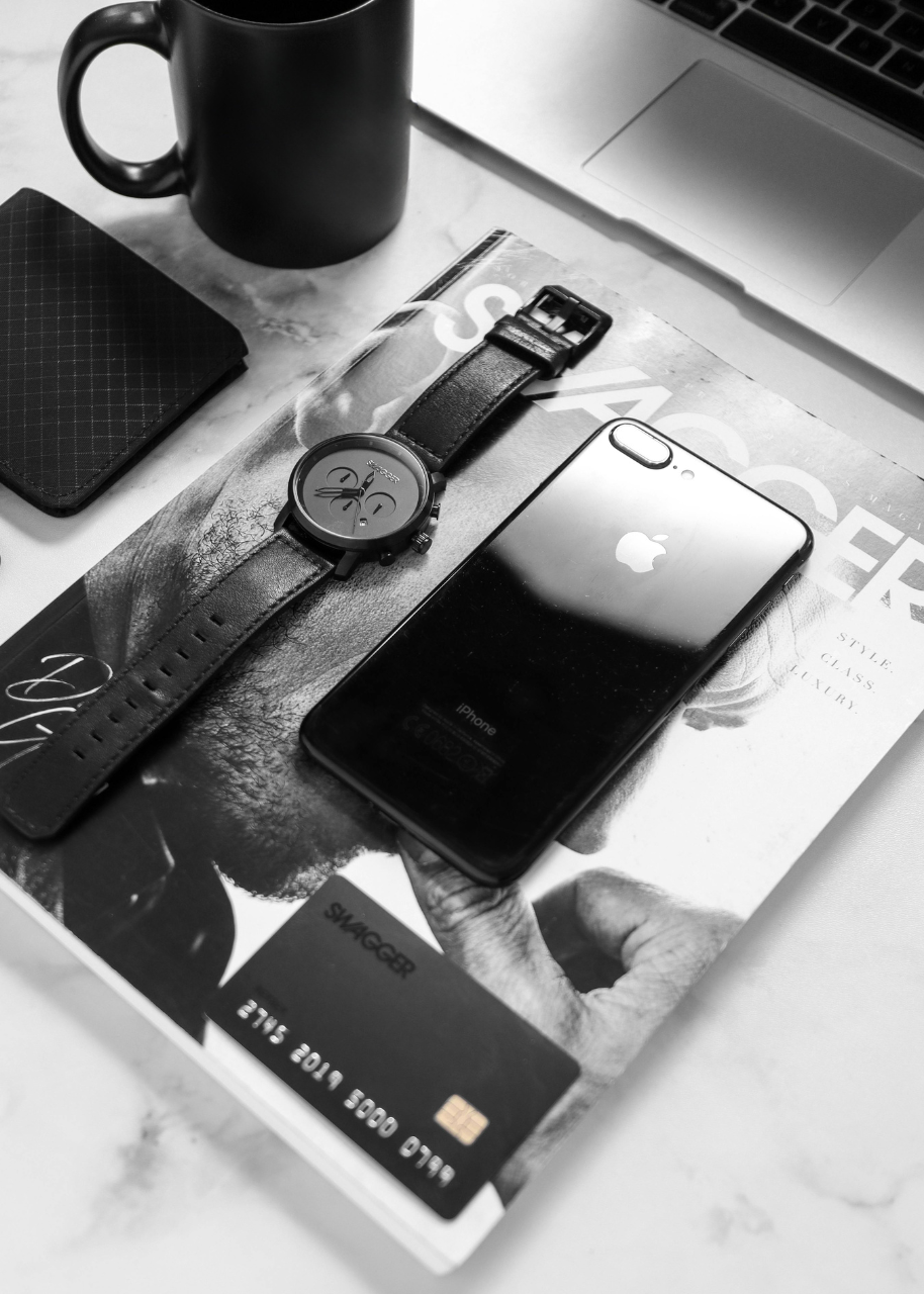 Montre de luxe noire, téléphone portable et carte bancaire sur papiers froissés — DB France Invest, financement et investissement